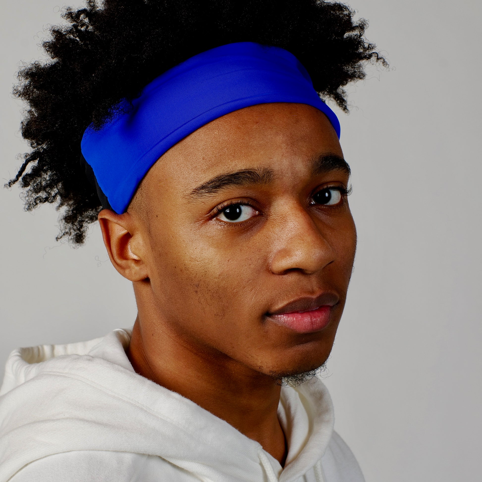 Young black male wearing royal blue cooling headband by Oro Sports